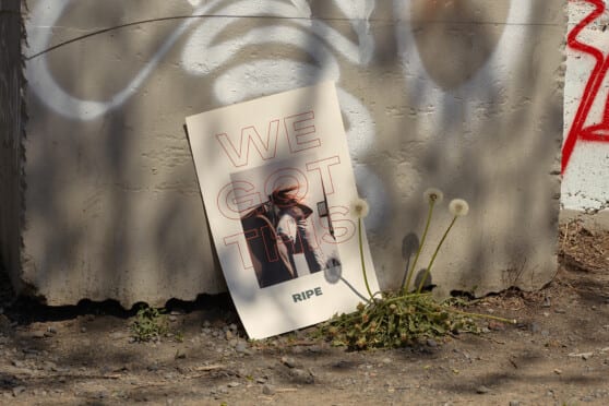 custom ripe poster leaned against a wall with graffiti