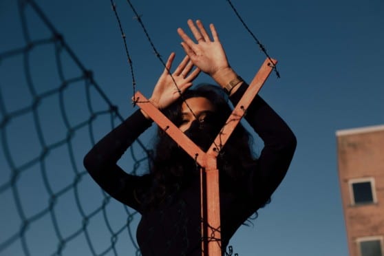 model poses with barbed wire fence